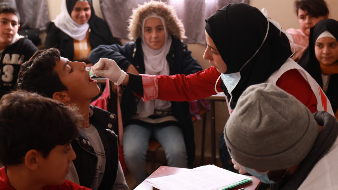 Children receive cholera vaccine in a primary school in Arsal