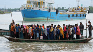 A crowd of climate migrant workers hurries to attend to their office in time after the cross of Poshur river by boat at Mongla city in Bagerhat, Bangladesh