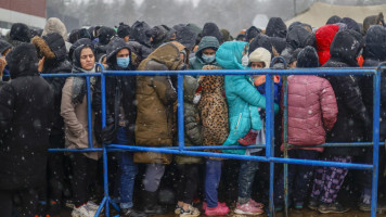 Migrants receive humanitarian aid donated by Grodno people as migrants continue to wait at a closed area allocated by Belarusian government the Belarusian-Polish border in Grodno, Belarus on November 27, 2021 [Getty Images]