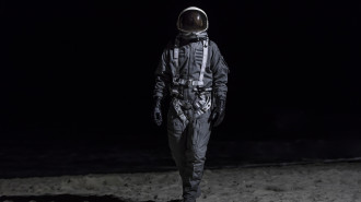 An astronaut standing on an apparent replica of the Moon or another similar surface