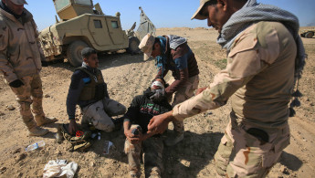  Iraqi security forces evacuate a comrade - AFP