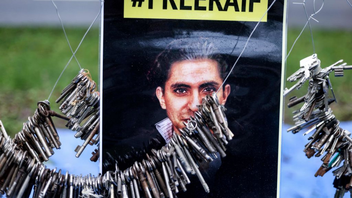 A poster calling for Raif Badawi to be freed. Keys are suspended on wires around it