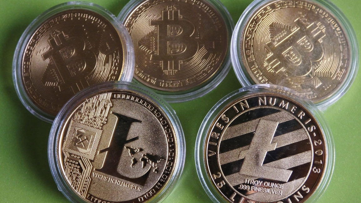 Three physical Bitcoin coins with two physical Litecoin coins
