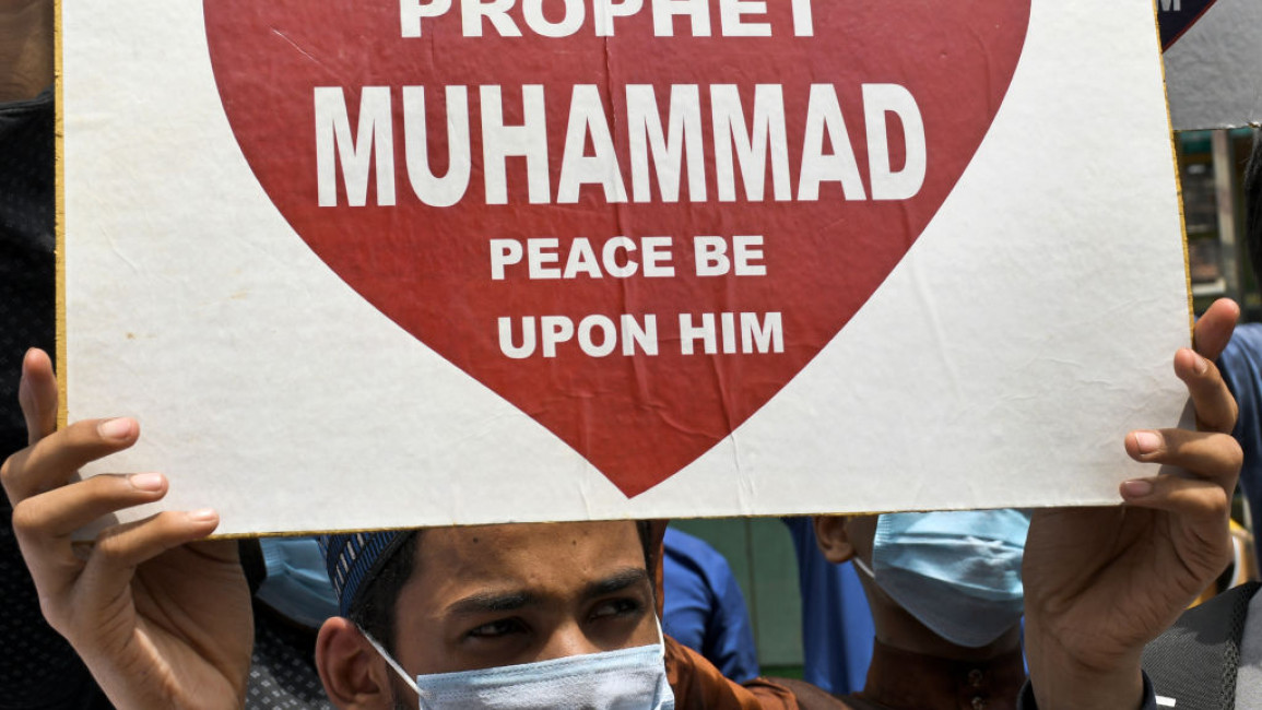 A man holding a sign reading: "I love Prophet Muhammad, peace be upon him."