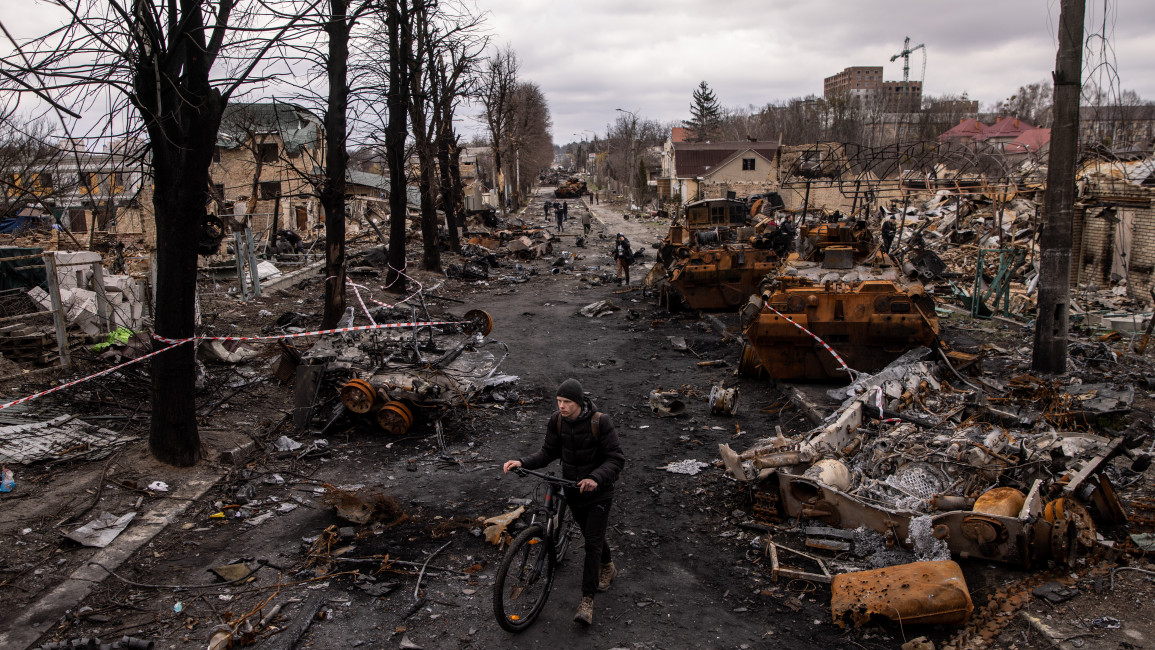 A man walks through debris and destroyed Russian military vehicles on a street in Bucha, where the Ukrainian government has accused Russian forces of committing a "deliberate massacre", on April 06, 2022. [Getty]