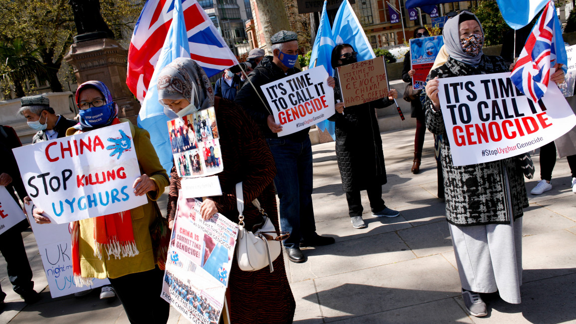 Members of the Uighur community and human rights activists demonstrate outside the Houses of Parliament in London