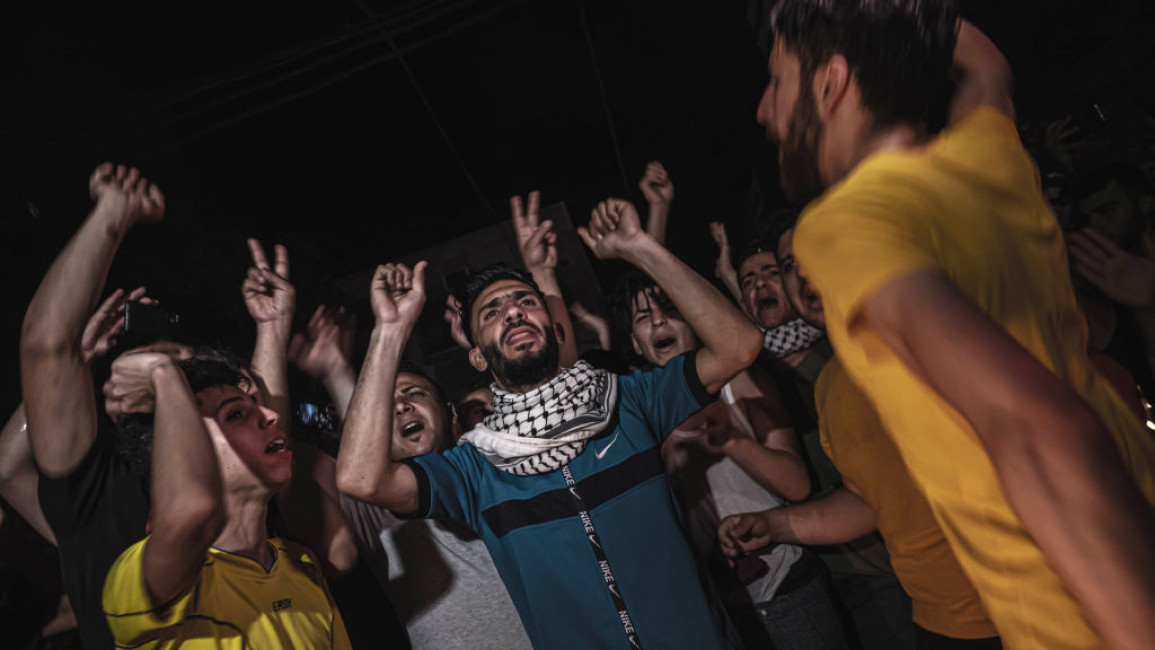 Young men celebrate the ceasefire with Israel in Gaza City