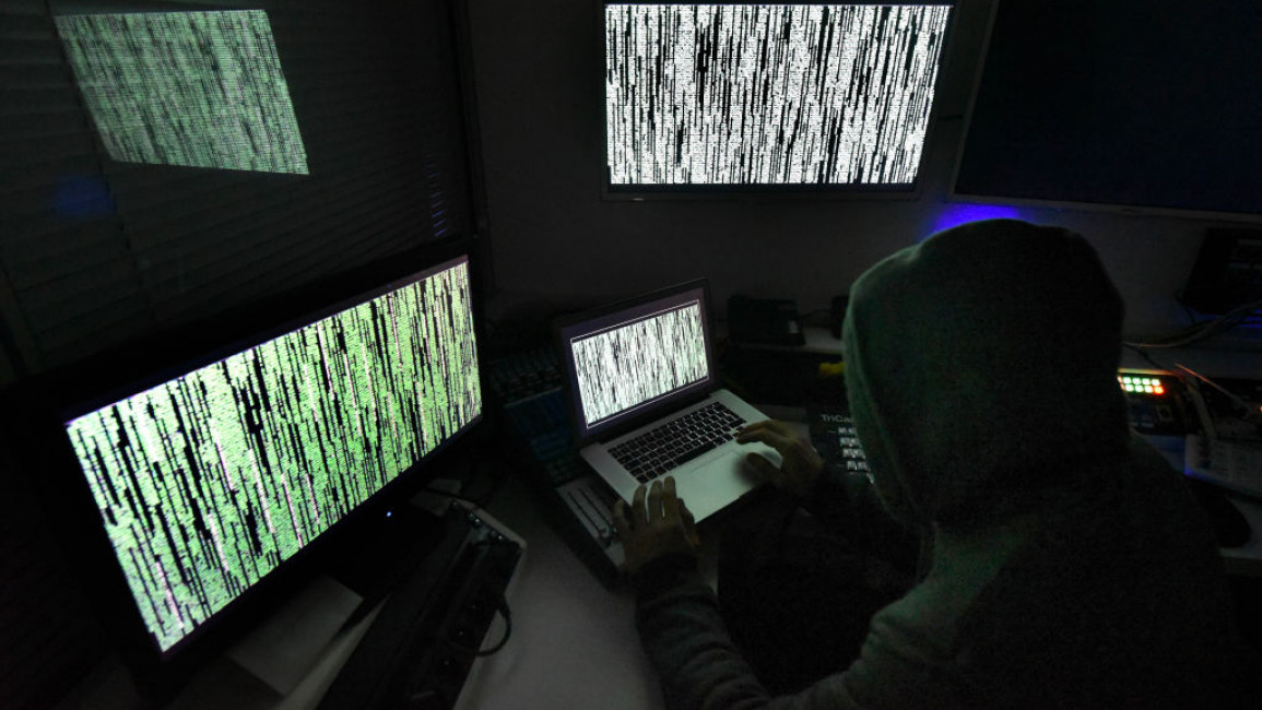 A hacker with multiple computer screens