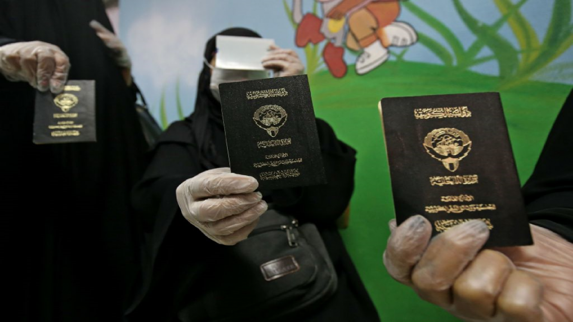 Kuwaiti women hold passports in vote