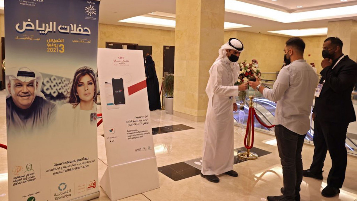Saudi staff checking attendant's mobiles for vaccine certificates or a negative Covid-19 test, at the entrance of a theatre hosting the first concert in the Saudi capital Riyadh since the start of the COVID-19 pandemic.