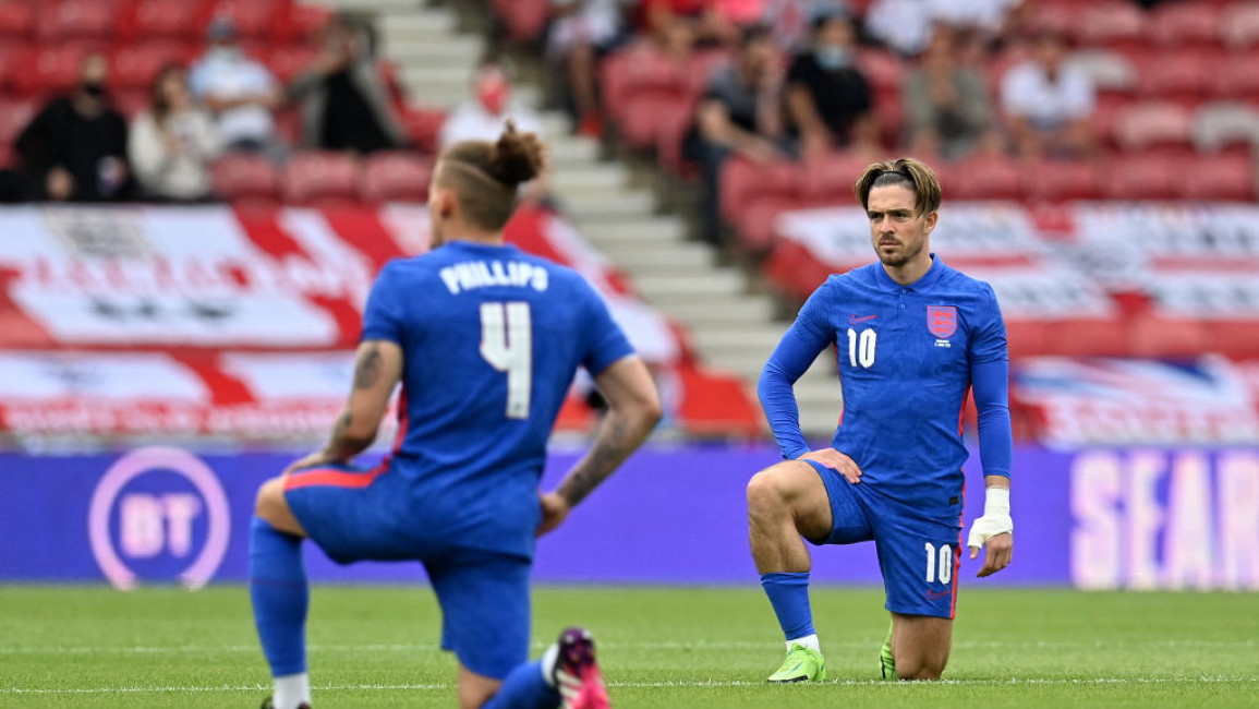 England's Declan Rice (L) and Jack Grealish (R) take a knee ahead of the football match against Romania at the Riverside Stadium in Middlesbrough, England on 6 June, 2021.