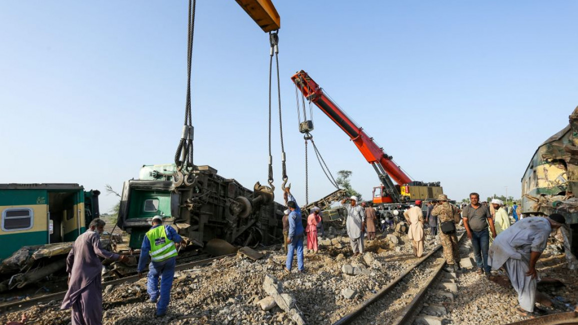 Workers remove a crashed train wreck