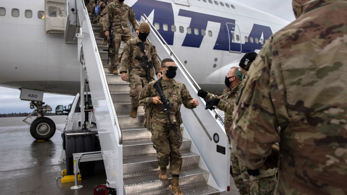US troops walking down the stairs to leave an airplane