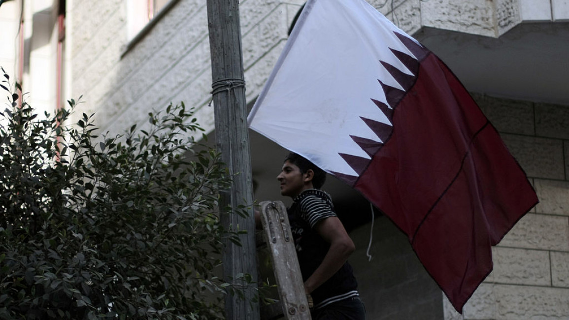 A Qatari flag being hung in Gaza