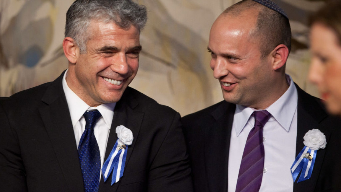 Yair Lapid (L) speaks to Naftali Bennett (R) during a reception marking the opening of the 19th Knesset (Israeli parliament) on 5 February, 2013. [Getty]