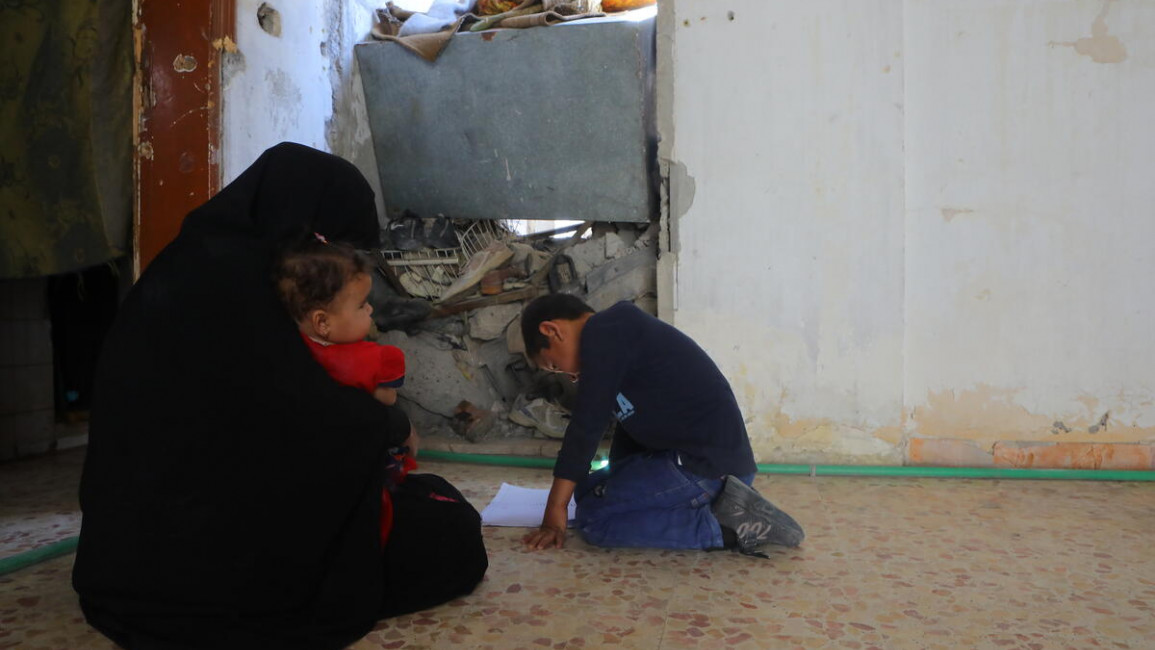 A family living in a damaged home in Raqqa, Syria