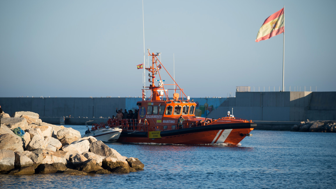 A Spanish flag is seen as a rescue boat carrying migrants arrives at the port of Motril [Getty]