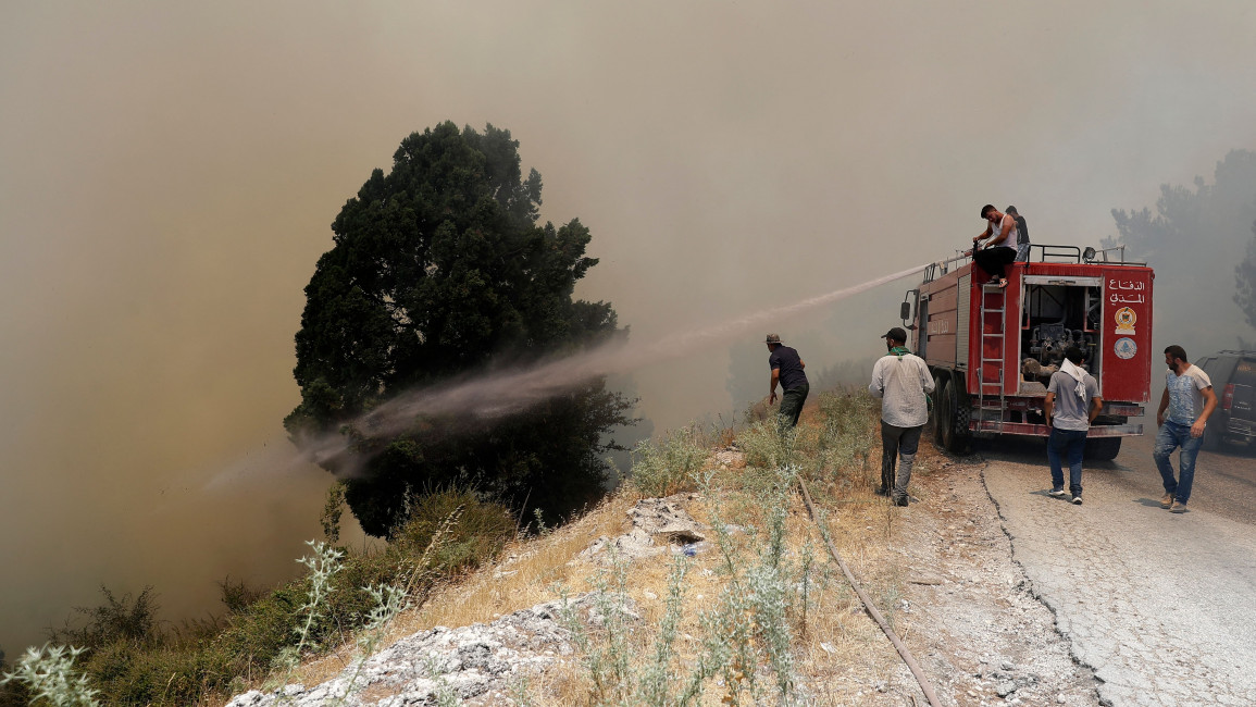 Firefighters and volunteers try to extinguish a fire in the forests of Qubayyat village in northern Lebanon [Getty]