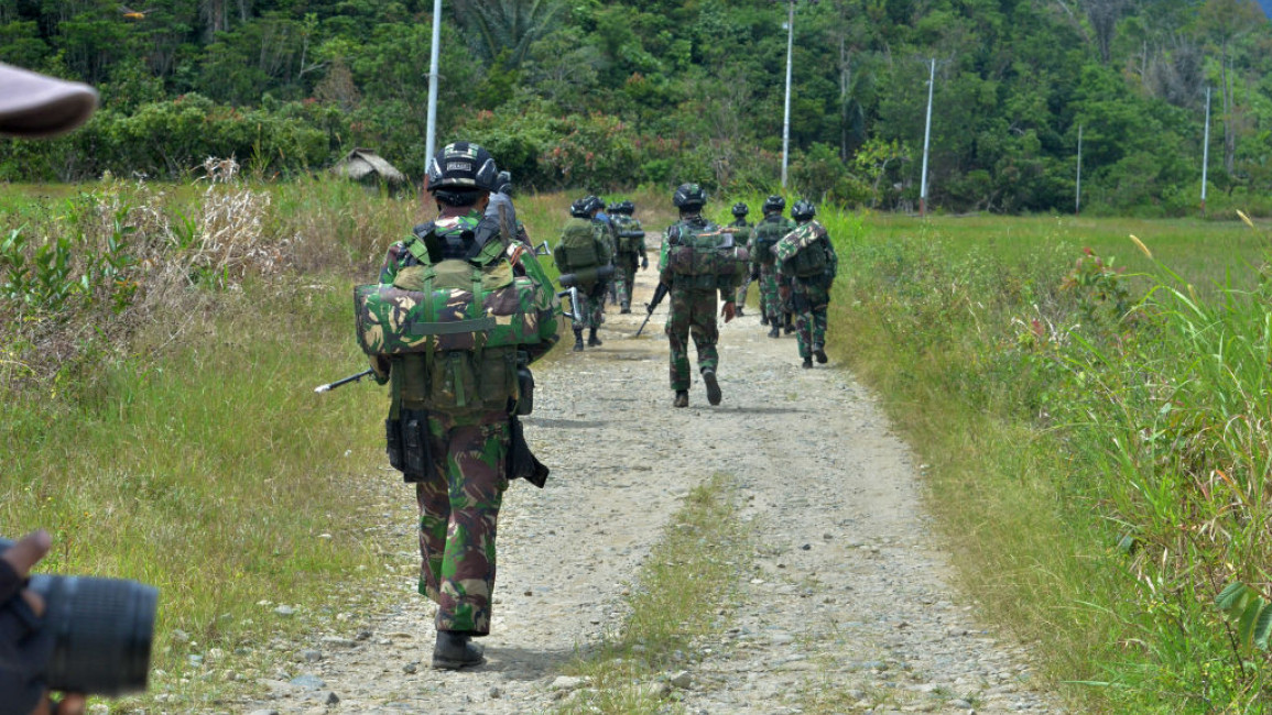 Indonesian soldiers walking down a path