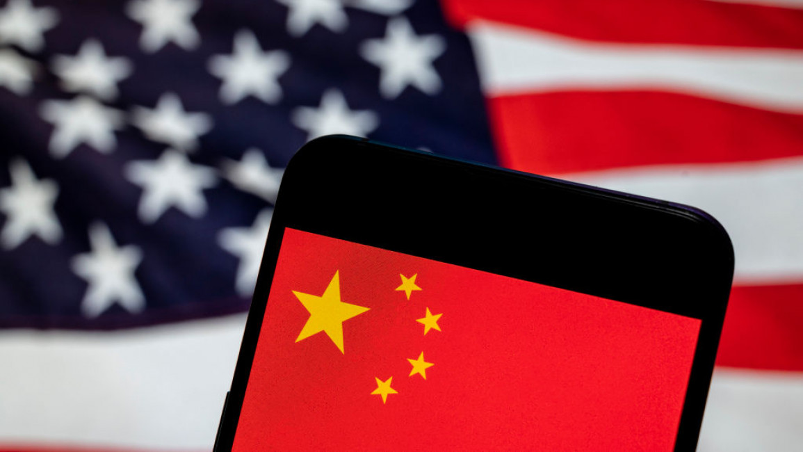 The Chinese flag on a mobile phone against a US flag background