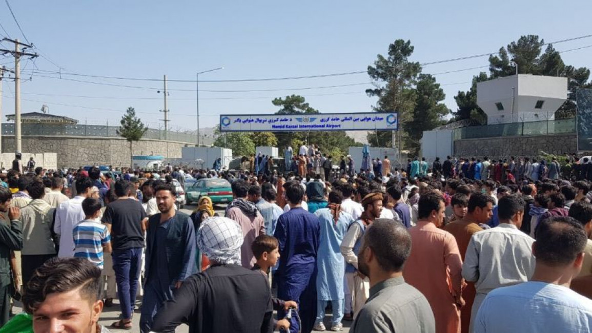  Afghans crowd at the tarmac of the Kabul airport