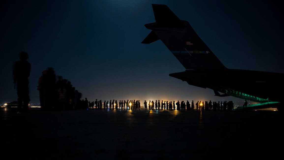 An air crew prepares to load evacuees aboard a C-17 Globemaster III aircraft in support of the Afghanistan evacuation at Hamid Karzai International Airport on August 21, 2021. [Getty]