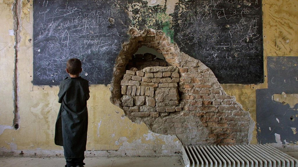 An Afghan child stands inside the ruins of the devastated but functioning Habibia High School in Kabul, Afghanistan. [Getty]