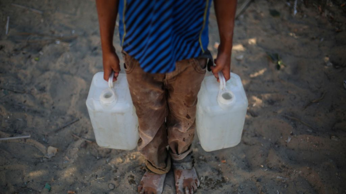 : Palestinian children collect drinking water - Getty