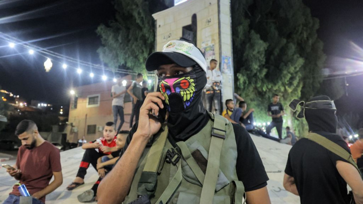 One of several militant gunmen belonging to the Aqsa, Qassam, and Islamic Jihad brigades of the various armed Palestinian factions looks on during a militant march through the Jenin camp for Palestinian refugees in the north of the occupied West Bank late on August 18, 2021.
