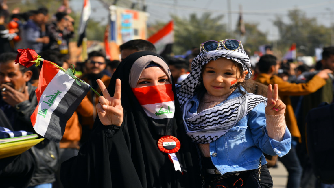 Iraqi woman holds V sign for victory during protest