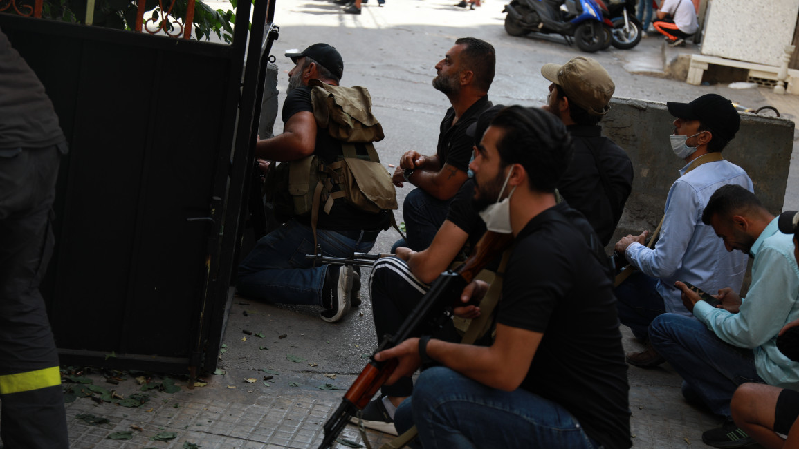 Gunmen huddle by Tayouneh roundabout. (William Christou/The New Arab)