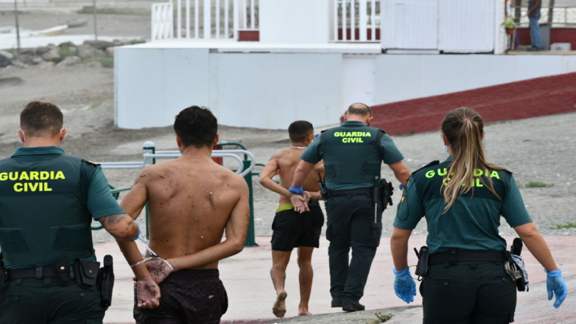Civil guards escort two Moroccan migrants in Ceuta
