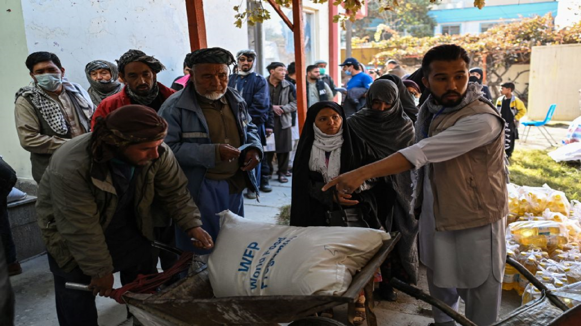 People wait in line during a World Food Programme food distribution in Kabul