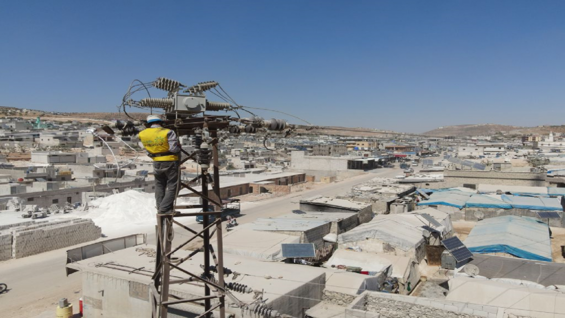 Man works on electricity pole in Syria