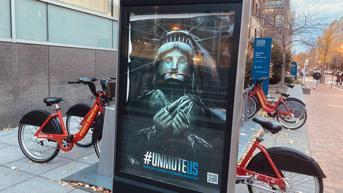 An ad by the Freedom Initiative's Unmute US campaign at a bikeshare stop in Washington, DC shows the Statue of Liberty being muzzled and shackled. (The New Arab)