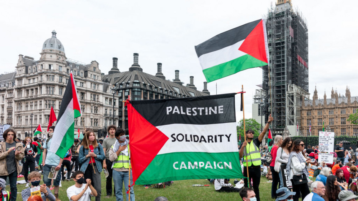 A protest with Palestinian flags, including one reading "Palestine Solidarity Campaign"