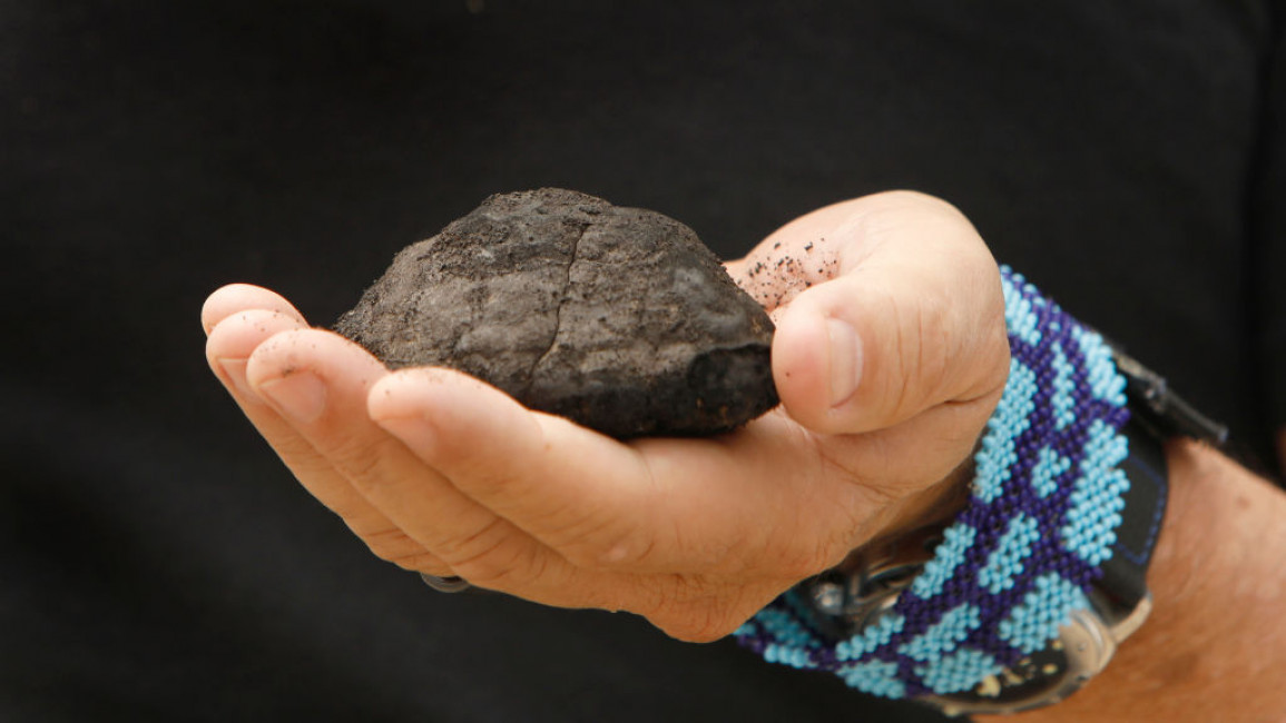 A man holding an extracted piece of ore