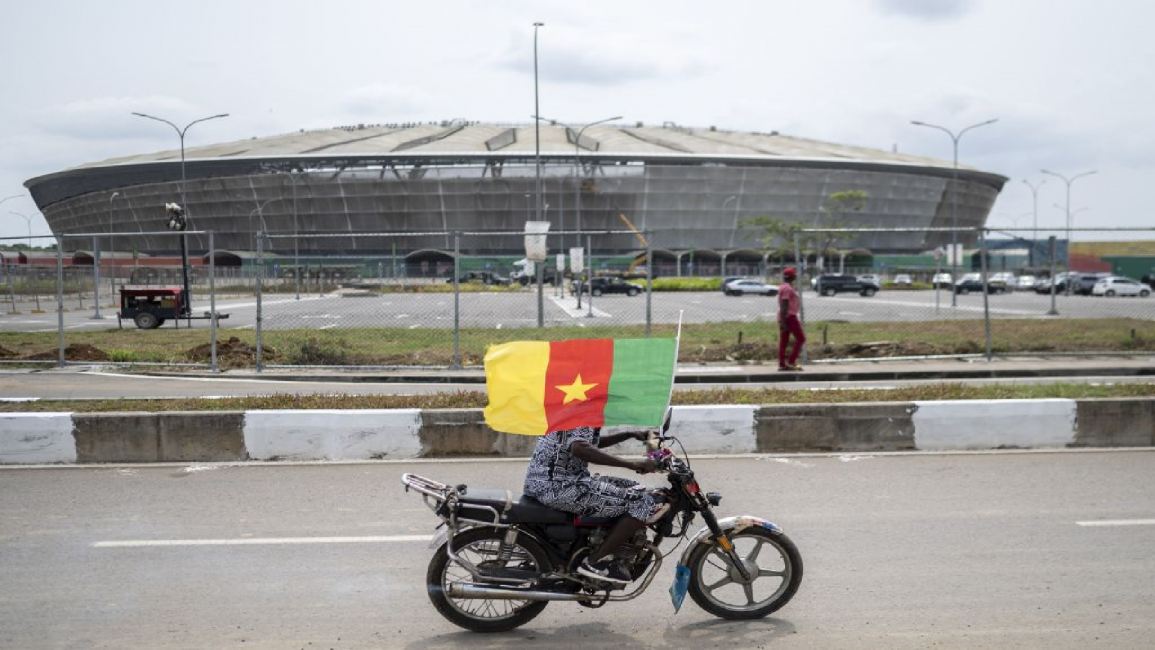 A Cameroon football fan rides his motorbike nearby the Japoma Stadium in Douala on January 9, 2022.