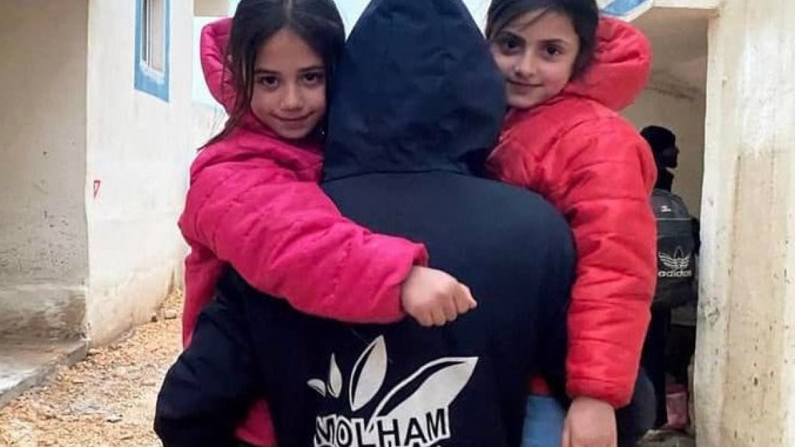 A volunteer for Syrian NGO Molham carries two Syrian children. (Image provided courtesy of Molham).