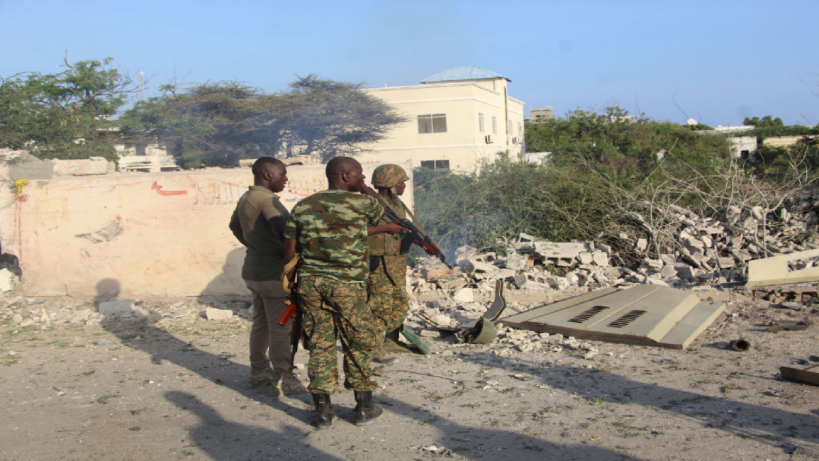 African Union Mission to Somalia (AMISOM) soldiers stand at the scene of a suicide bombing