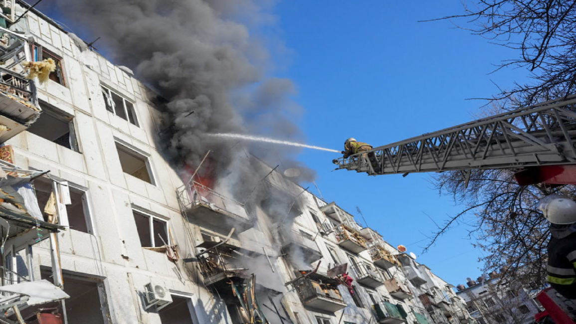 Ukrainian firefighters try to extinguish a fire after an airstrike hit an apartment complex in Chuhuiv, Ukraine
