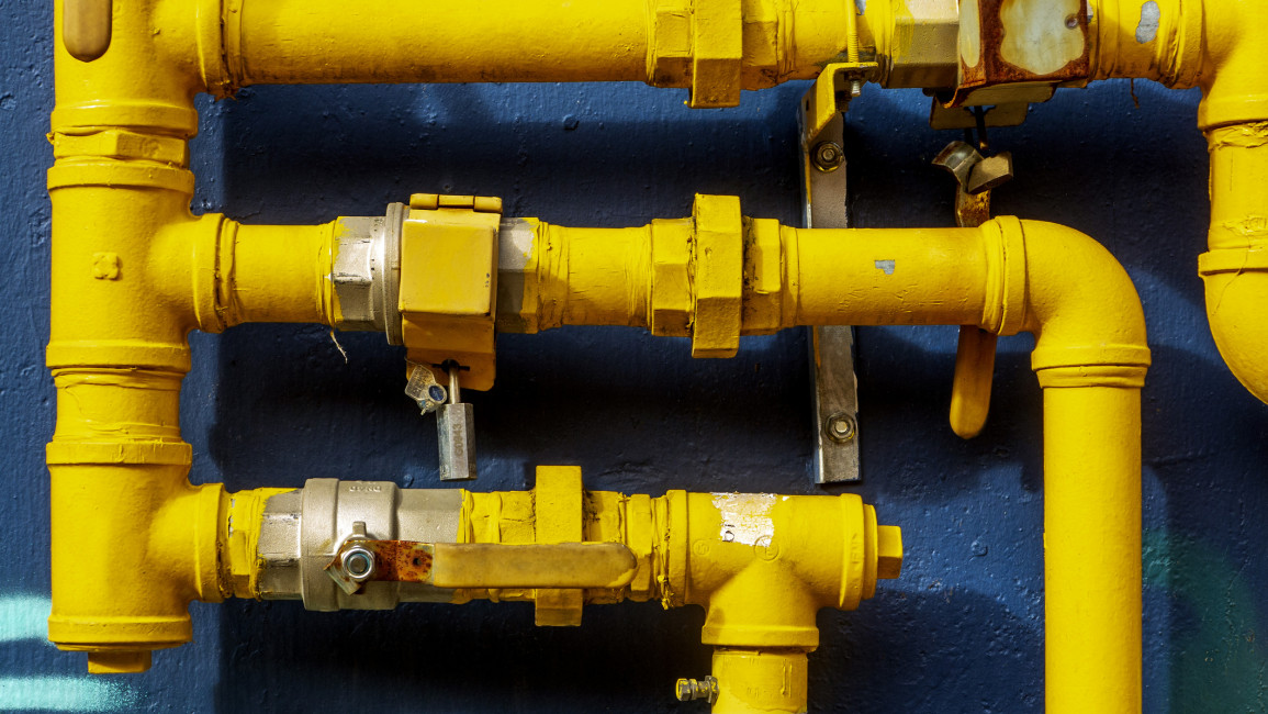 Yellow gas pipes against a blue backdrop