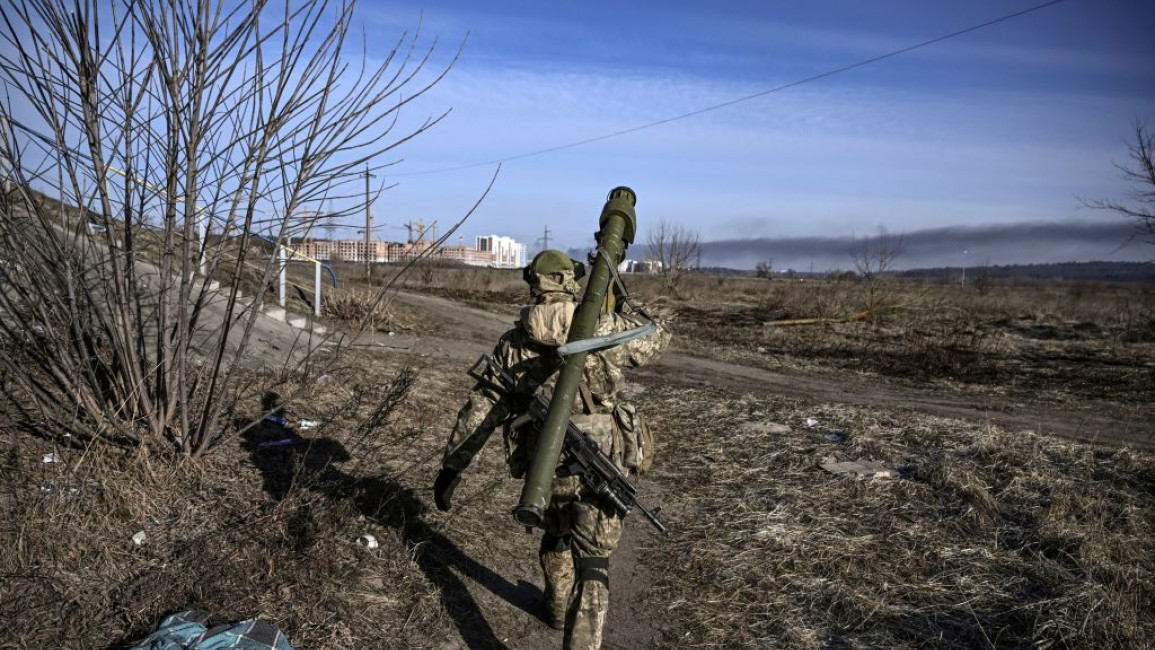 A photo taken from behind a Ukrainian soldier who is walking forwards
