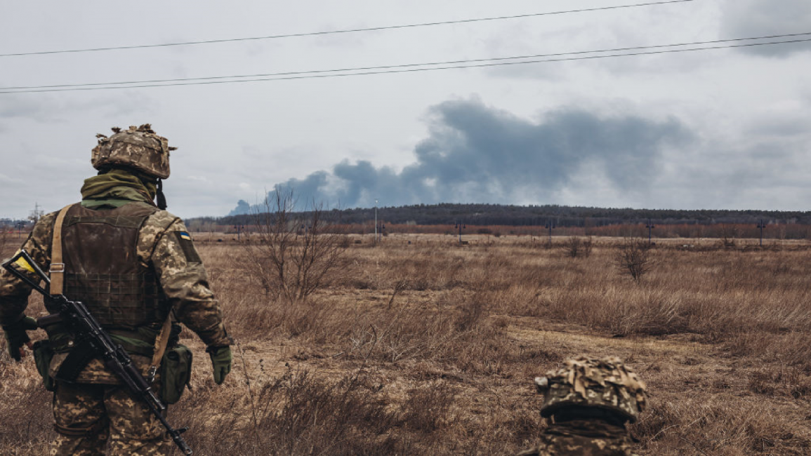 An Ukrainian army soldier watches the smoke from shelling in Irpin, Ukraine