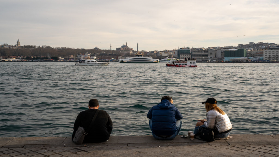 People sit by the sea in Istanbul