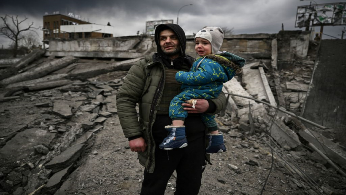 Man carrying child in Irpin, Ukraine