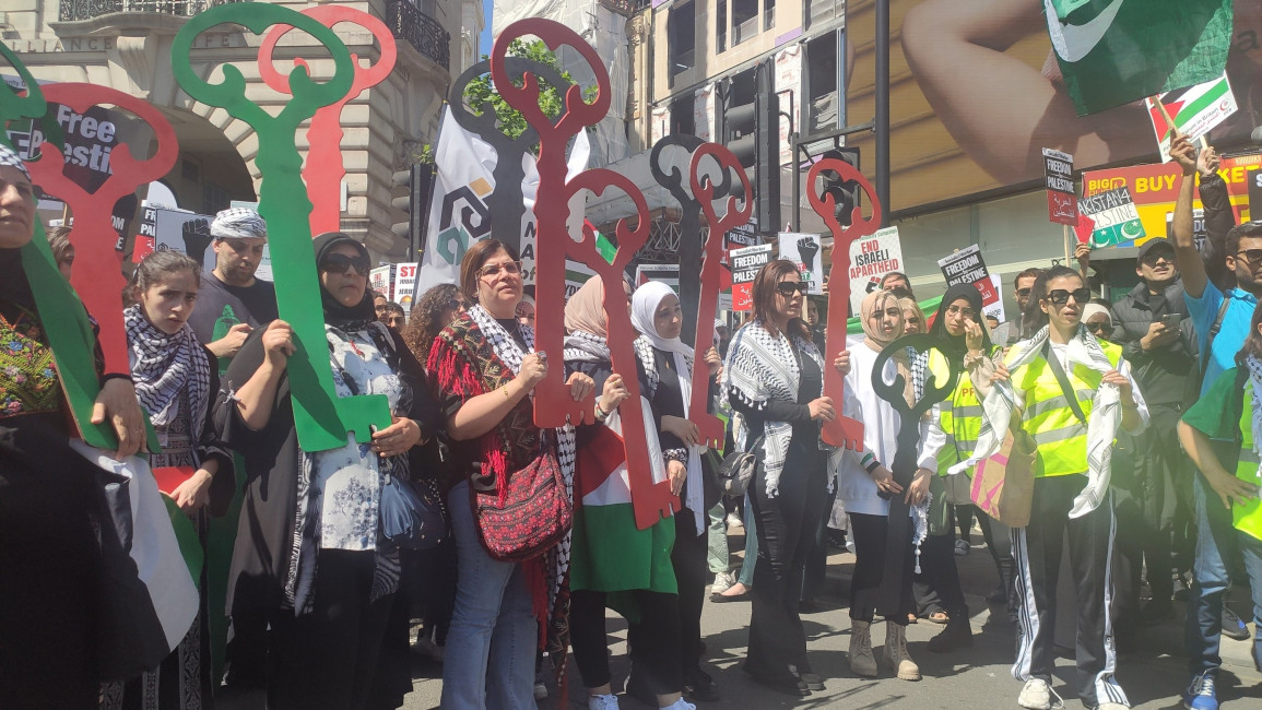 Palestinians hold green, black and red keys that symbolise the homes stolen from them by Israel