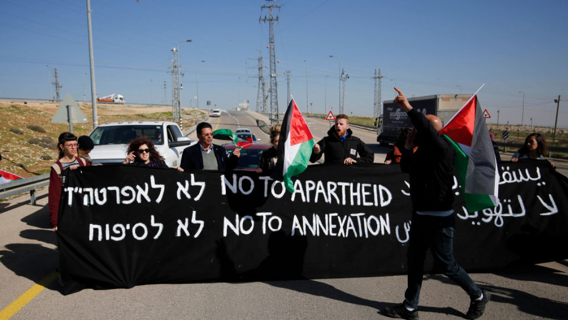 Demonstrators holding a banner with text reading: "No to apartheid. No to annexation."