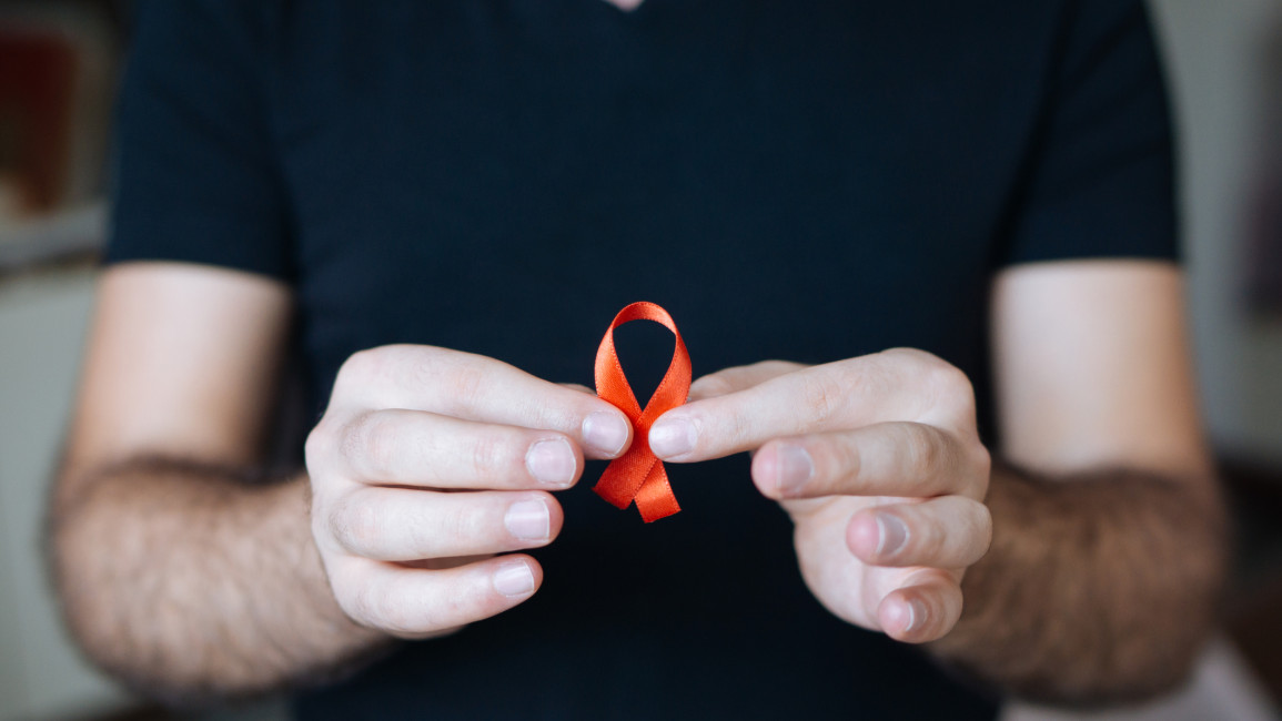 A person holding a red ribbon.