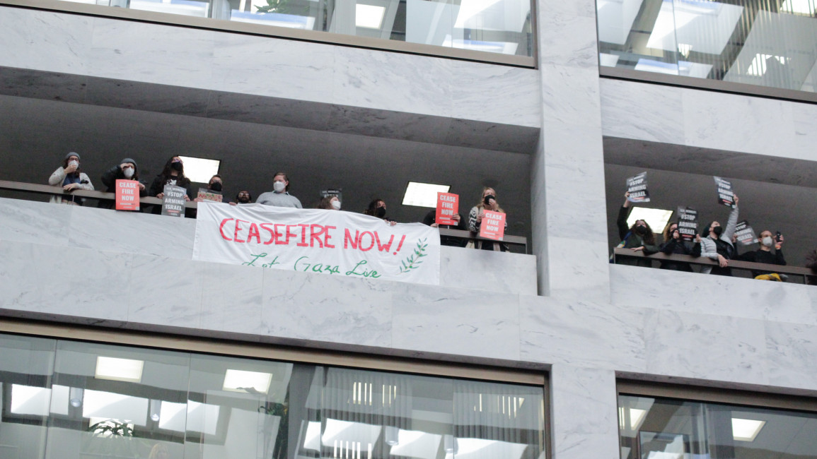 Activists outside of Senator Jeff Merkley's office in Washington, DC on 3 November chant "ceasefire now" and carry signs calling for the senator to stop arming Israel. Activists were arrested shortly after. The sit-in was one of eight held at progressive Democratic senators' offices. [Laura Albast for The New Arab]